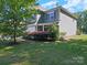 Charming two-story home featuring well-manicured lawn, front porch, and lush landscaping at 159 Autumn Mist Rd, Statesville, NC 28677