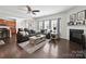Open-concept living room with a fireplace, plush sofa, and dark hardwood floors at 159 Autumn Mist Rd, Statesville, NC 28677