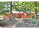 View of the backyard of a brick home, featuring a deck and mature trees at 16509 Kimbolten Dr, Huntersville, NC 28078