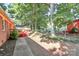Wide backyard features a brick house, a deck, tall trees, and a sidewalk at 16509 Kimbolten Dr, Huntersville, NC 28078