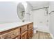 Bright bathroom with wood-look floor, bath tub, and wooden vanity with a large, round mirror at 16509 Kimbolten Dr, Huntersville, NC 28078