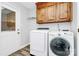 Efficient laundry room with wood cabinets, modern washer and dryer, and access to an exterior door at 16509 Kimbolten Dr, Huntersville, NC 28078