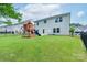 Large backyard with playset, green grass, and a black fence at 1736 Rhynes Trl, Rock Hill, SC 29732