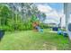 Spacious backyard with lush lawn, playground, grill, and blue sky at 1736 Rhynes Trl, Rock Hill, SC 29732