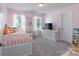 This spacious bedroom has pink walls, plush carpet, dresser, TV, and lots of natural light at 1736 Rhynes Trl, Rock Hill, SC 29732
