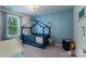 Bright bedroom showcasing blue board and batten wall, window, and unique house-shaped bed frame at 1736 Rhynes Trl, Rock Hill, SC 29732