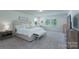 Main bedroom with large bed, white bedding, sitting area, and two windows at 1736 Rhynes Trl, Rock Hill, SC 29732