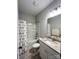 Well-lit bathroom with tub-shower combo, granite countertop, and whale shower curtain at 205 Spring Creek Dr, Mount Holly, NC 28120