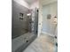 Modern bathroom featuring gray tiled walk-in shower with decorative trim and a glass enclosure at 205 Spring Creek Dr, Mount Holly, NC 28120