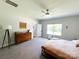 Sunlit bedroom with a ceiling fan, dresser, and large window showcasing the property's natural surroundings at 205 Spring Creek Dr, Mount Holly, NC 28120