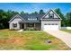 Charming home featuring gray siding, a two-car garage, a well-manicured lawn, and delightful landscaping at 205 Spring Creek Dr, Mount Holly, NC 28120