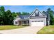 The property boasts charming curb appeal, featuring a well-manicured lawn and a classic garage at 205 Spring Creek Dr, Mount Holly, NC 28120