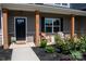 Charming covered porch with seating and meticulous landscaping provides a cozy outdoor space at 205 Spring Creek Dr, Mount Holly, NC 28120