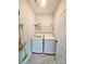 Functional laundry room with washer, dryer, storage, and tile flooring at 205 Spring Creek Dr, Mount Holly, NC 28120