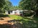 Property features a home with a carport and a cozy front porch, nestled amongst mature trees at 208/210 Damascus Rd, Gastonia, NC 28056