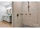 This shower features neutral tile, a shower head, and convenient shelving for an organized and modern bathroom space at 237 Mariposa Rd, Stanley, NC 28164