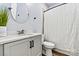 A clean, bright bathroom with a white vanity, round mirror, and decorative accents at 237 Mariposa Rd, Stanley, NC 28164