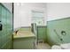 Quaint bathroom with vintage green tile, and accessibility handrail at 2417 Statesville Blvd, Salisbury, NC 28147