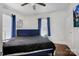 Well-lit bedroom with hardwood floors, a plush bed, and blue curtains for privacy at 2417 Statesville Blvd, Salisbury, NC 28147