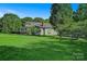 Charming home featuring a large, well-maintained lawn, gravel driveway, and mature trees at 2417 Statesville Blvd, Salisbury, NC 28147