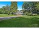 Charming home with a gravel driveway surrounded by mature trees and a spacious front yard at 2417 Statesville Blvd, Salisbury, NC 28147