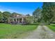 Beautiful home with covered porch and gravel driveway, nestled among mature trees and expansive lawn at 2417 Statesville Blvd, Salisbury, NC 28147