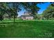 Backyard view showing home's exterior, surrounded by lush greenery and a spacious lawn at 2417 Statesville Blvd, Salisbury, NC 28147