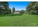 Sprawling green lawn surrounds this cozy home with mature trees and a serene, countryside setting at 2417 Statesville Blvd, Salisbury, NC 28147