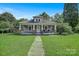 Charming home featuring a welcoming front porch with classic column details and lush lawn at 2417 Statesville Blvd, Salisbury, NC 28147