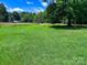 Spacious grassy front yard featuring a mature tree, and a home is visible in the background at 2417 Statesville Blvd, Salisbury, NC 28147