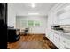 Bright kitchen featuring laminate wood flooring, white cabinets, and stainless steel appliances at 2417 Statesville Blvd, Salisbury, NC 28147