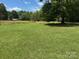 Expansive green lawn leading to a cozy home nestled amongst mature trees at 2417 Statesville Blvd, Salisbury, NC 28147