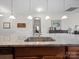 Kitchen island with a granite countertop, stainless steel sink, and view into other rooms at 24604 Blue Heron Cir, Lancaster, SC 29720