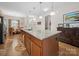 Spacious kitchen island with granite countertops, sink, wooden cabinets and a view of the dining area at 24604 Blue Heron Cir, Lancaster, SC 29720