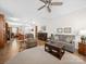 Open-concept living room flowing into the kitchen with hardwood floors and ceiling fan at 24604 Blue Heron Cir, Lancaster, SC 29720