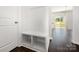 Cozy entryway featuring a built-in bench with storage, dark wood floors, and access to the living area at 3001 Sadler Woods Ln, Charlotte, NC 28214