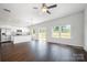 Bright, open-concept living space featuring dark floors, a ceiling fan, and a seamless flow to the modern kitchen at 3001 Sadler Woods Ln, Charlotte, NC 28214