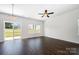 Bright living room featuring a ceiling fan, dark wood floors, windows, and sliding glass doors to backyard at 3001 Sadler Woods Ln, Charlotte, NC 28214