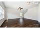 Spacious living room with dark hardwood floors, bright white walls, and a ceiling fan at 3001 Sadler Woods Ln, Charlotte, NC 28214