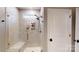Modern walk-in shower with sleek glass doors, built-in niche, and a convenient shower bench at 320 Secretariat Dr, Iron Station, NC 28080