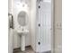 Well-lit powder room with pedestal sink, oval mirror, and wood-look flooring at 325 Hancock Union Ln, Rock Hill, SC 29732