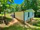 Home's exterior featuring a lush green yard, mature trees, a partial view of the home's foundation, and steps at 325 Scaley Bark Dr, Salisbury, NC 28147