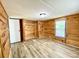A bedroom featuring wood-paneled walls, modern flooring, and a closet at 325 Scaley Bark Dr, Salisbury, NC 28147