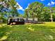 Charming ranch-style home with black trim, inviting deck and ramp access on a lush, tree-lined lot at 325 Scaley Bark Dr, Salisbury, NC 28147