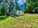 Ranch-style home with a ramp for accessibility and a lush lawn surrounded by mature trees on a sunny day at 325 Scaley Bark Dr, Salisbury, NC 28147