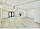 Bright, open-concept living room leading into kitchen with modern floors, white walls, and ceiling beams at 325 Scaley Bark Dr, Salisbury, NC 28147