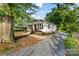 Quaint home featuring white siding, a gravel driveway, and a cozy front porch at 402 Ford St, Kannapolis, NC 28083