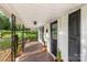 Inviting front porch with wood flooring, wrought iron posts, and decorative potted plants at 402 Ford St, Kannapolis, NC 28083