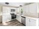Well-lit kitchen featuring white cabinets, stainless steel appliances, and modern fixtures at 402 Ford St, Kannapolis, NC 28083