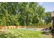 Well-maintained backyard featuring a modern pool with a built-in spa, surrounded by lush greenery and a manicured lawn at 412 Jefferson Dr, Charlotte, NC 28270
